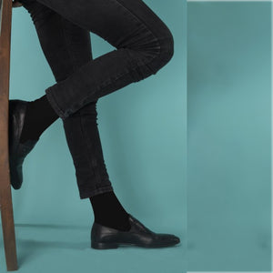 photo of man legs in slim pants wearing dark socks and leather shoes