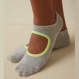 person wearing grey and yellow yoga socks