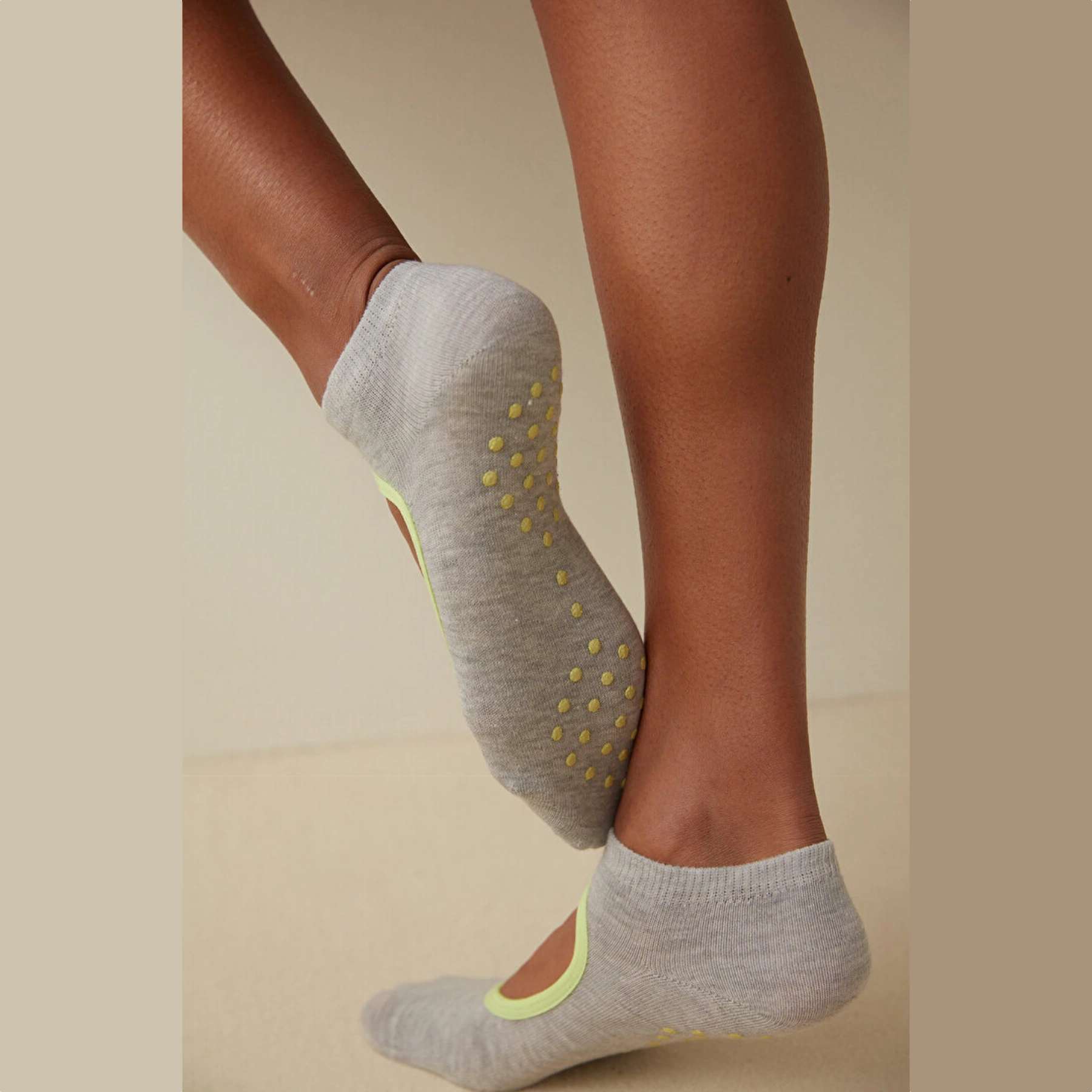 person wearing grey and yellow yoga socks