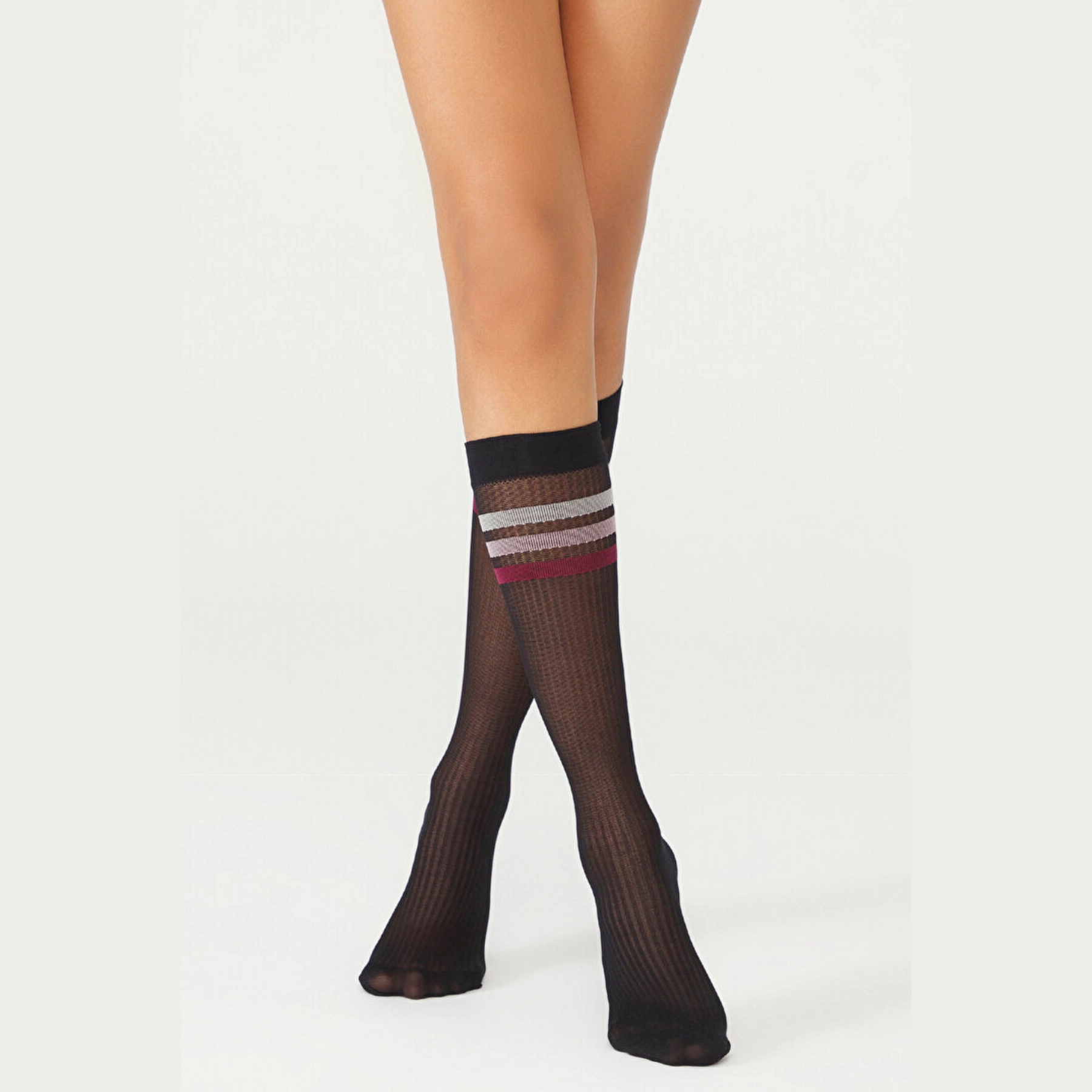 person wearing sheer black knee high socks with multicoloured striped cuff