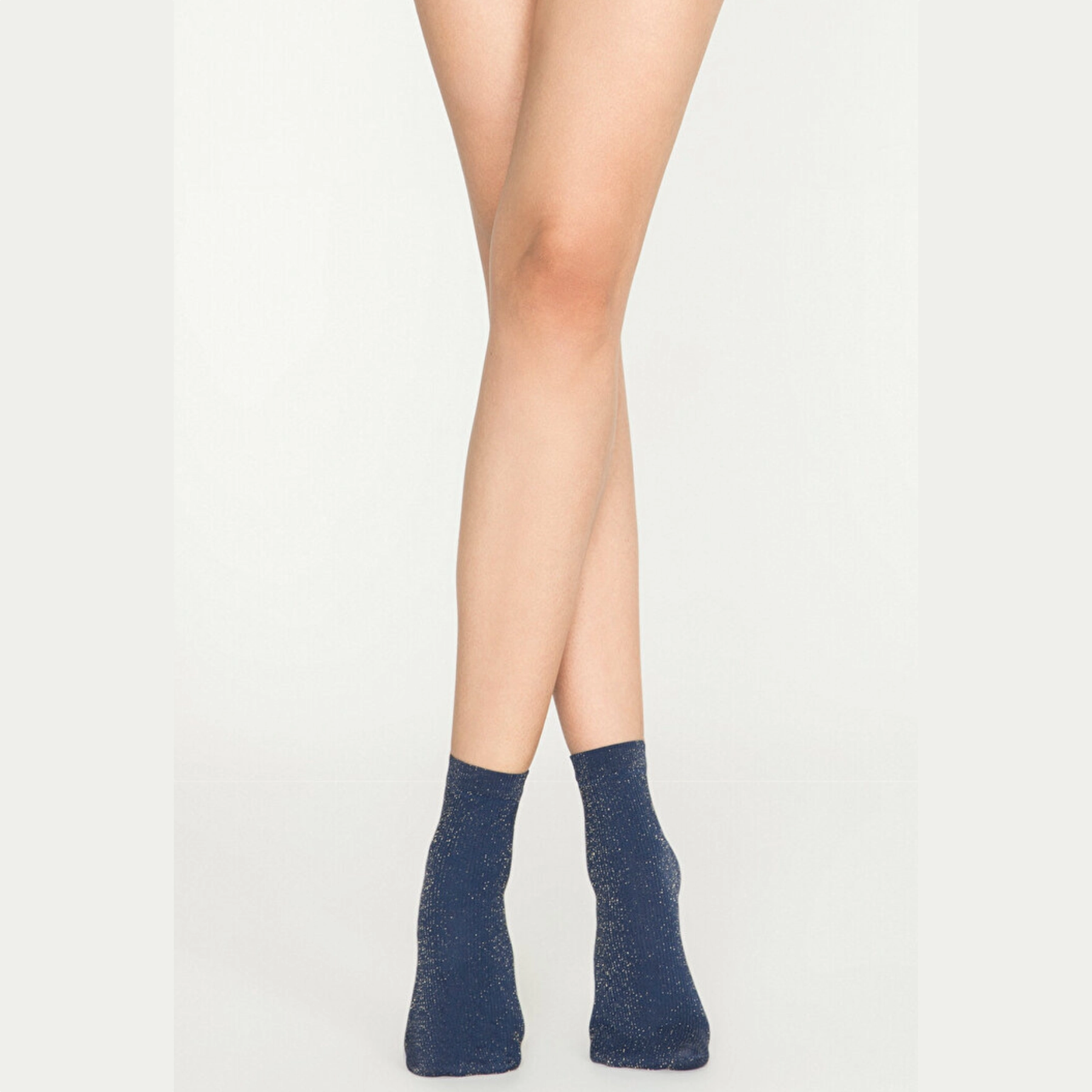 Woman wearing navy gold sparkle ankle socks