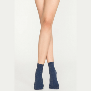 Woman wearing navy gold sparkle ankle socks